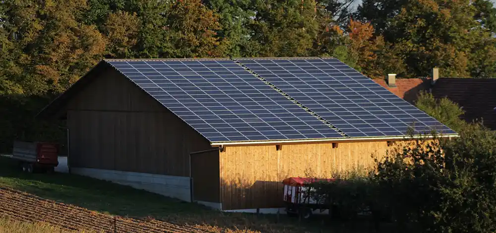Off grid solar energy cost - large rural solar panel array on barn roof